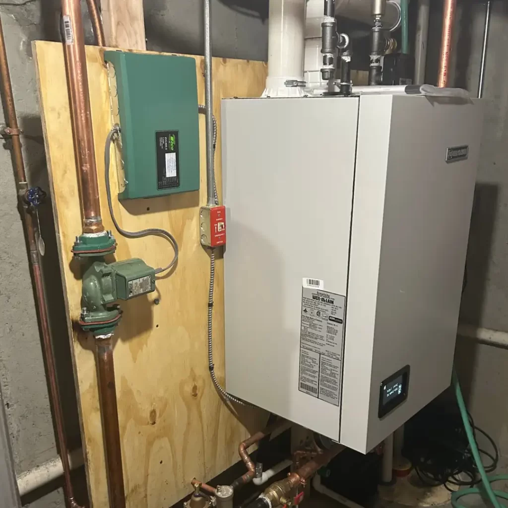 High efficiency wall mounted boiler installation with copper piping and circulation pump in a Rhode Island basement