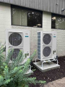 commercial heating and cooling maintenance technician servicing rooftop unit - commercial heating and cooling maintenance